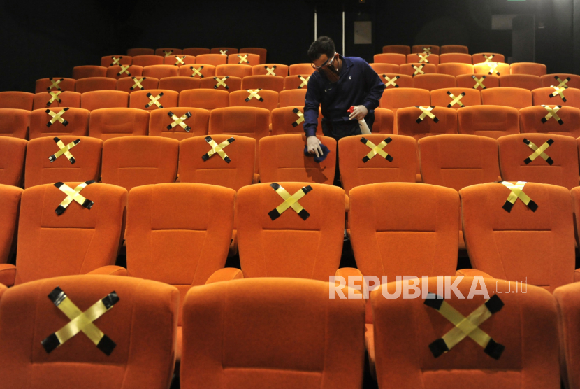 Karyawan membersihkan kursi penonton saat hari pertama pembukaan kembali Cinepolis Cinemas di Lippo Mall Kuta, Badung, Bali, Rabu (16/12/2020). Sejumlah bioskop di wilayah Bali kembali beroperasi dengan menerapkan protokol kesehatan COVID-19 sesuai dengan peraturan dan rekomendasi pemerintah seperti membatasi kapasitas di dalam studio menjadi 50 persen dan mewajibkan pengunjung untuk mengenakan masker. 