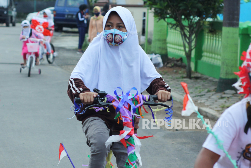 Sejumlah anak berkeliling komplek sambil mengayuh sepeda hias dengan memakai masker, di kawasan Lembang, Kabupaten Bandung Barat, Senin (17/8). Organisasi Kesehatan Dunia (WHO) mengatakan anak-anak berusia 12 tahun ke atas harus memakai masker untuk membantu mengatasi pandemi Covid-19 dalam kondisi yang sama seperti orang dewasa. 