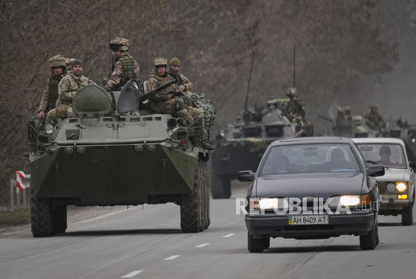 Prajurit Ukraina duduk di atas kendaraan lapis baja pengangkut personel yang mengemudi di jalan di wilayah Donetsk, Ukraina timur, Kamis, 24 Februari 2022. 