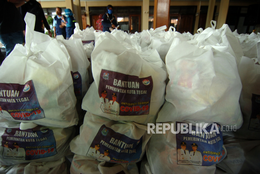 Petugas membagikan bantuan paket sembako bagi warga di wilayah yang terdampak penerapan PSBB (ilustrasi).