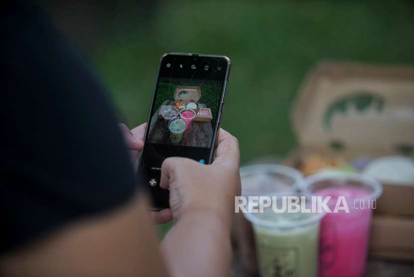Yogyakarta Data UKM untuk Akses Bansos Produktif. Pelaku UMKM memotret produk kuliner untuk diunggah di media sosial.