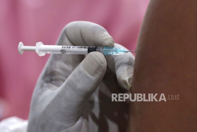 Seorang pria menerima suntikan vaksin Covid-19 saat vaksinasi massal untuk pedagang dan pekerja di Pasar Tanah Abang di Jakarta, Indonesia, Rabu (17/2).