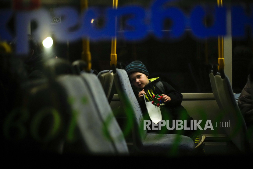 Seorang anak yang melarikan diri dari Mariupol bersama keluarganya menunggu di bus setibanya mereka di pusat penerimaan pengungsi di Zaporizhzhia, Ukraina, Minggu malam, 8 Mei 2022.  Perdana Menteri Hungaria Viktor Orban  mengumumkan keadaan darurat pada Selasa (24/5/2022).