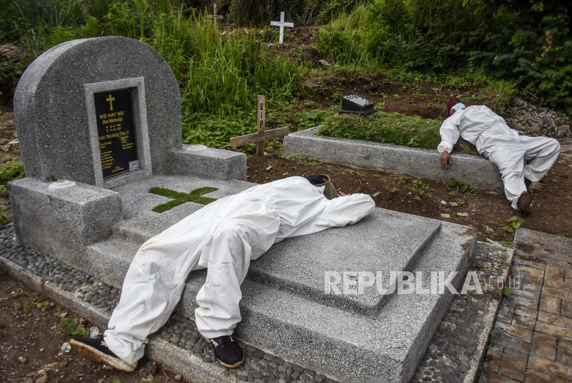 Sejumlah petugas pemikul jenazah mengenakan alat pelindung diri (APD) berisitirahat disela prosesi pemakaman dengan protokol Covid-19 di TPU Cikadut, Jalan Cikadut, Mandalajati, Kota Bandung, Selasa (15/6). (Ilustrasi)