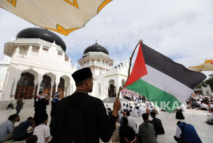 Para pengunjuk rasa memegang bendera berkumpul untuk mendukung warga Palestina di Masjid Raya Baiturrahman di Banda Aceh,  Rabu (8/11/2023).