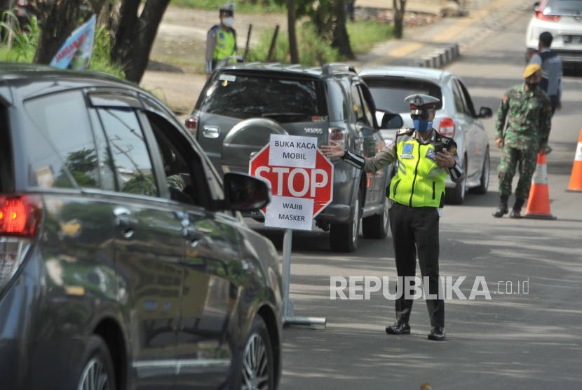 Petugas kepolisian berjaga di check point Jalan Kol Burlian Palembang, Sumatera Selatan, Selasa (26/5/2020). Sanksi bagi pelanggaran Pembatasan Sosial Berskala Besar (PSBB) di Kota Palembang mulai diberlakukan pada 26 Mei 2020 setelah berlangsung sejak 20 Mei lalu sebagai masa sosialisasi