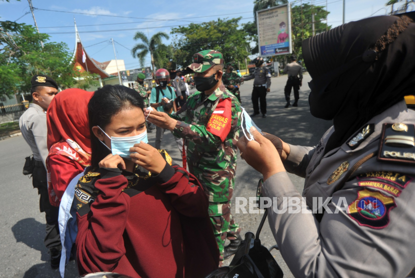 Personel kepolisian dan TNI memberikan masker kepada pengendara di Jl Sisingamangaraja Padang, Sumatra Barat. TNI dan Polri serta pihak terkait terus menyosialisasikan penggunaan masker dan imbauan jaga jarak kepada warga di tempat keramaian menyusul kasus COVID-19 yang terus meningkat.(ilustrasi)