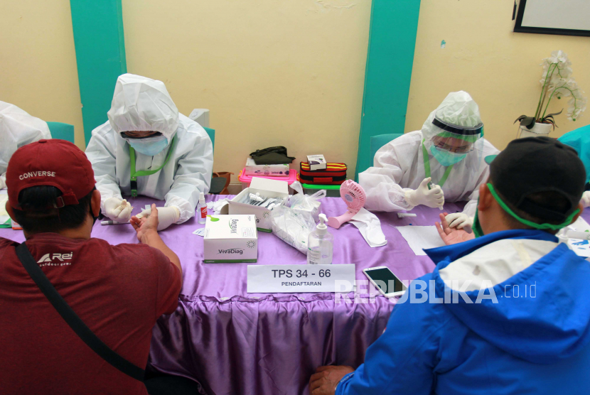 Petugas medis mengambil sampel darah anggota Panitia Pemungutan Suara ( PPS) 