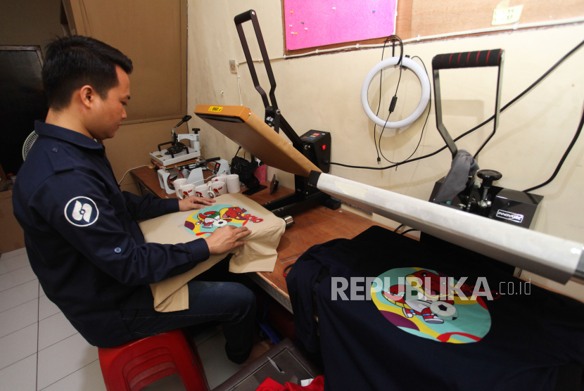 Pekerja menyablon kaus bertema sepak bola di salah satu tempat produksi suvenir di Kendangsari, Surabaya, Jawa Timur, untuk menyambut Piala Dunia U-17. 