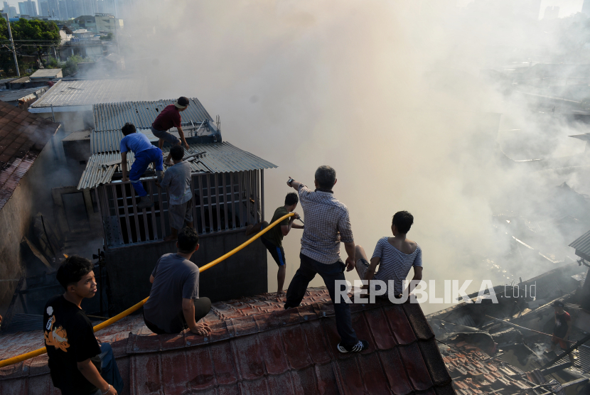 Warga membantu petugas Dinas Gulkarmat DKI saat memadamkan api di Jalan Anyer Nomor 15, RT 06, RW 09, Kecamatan Menteng, Jakarta Pusat, Jumat (29/9/2023).