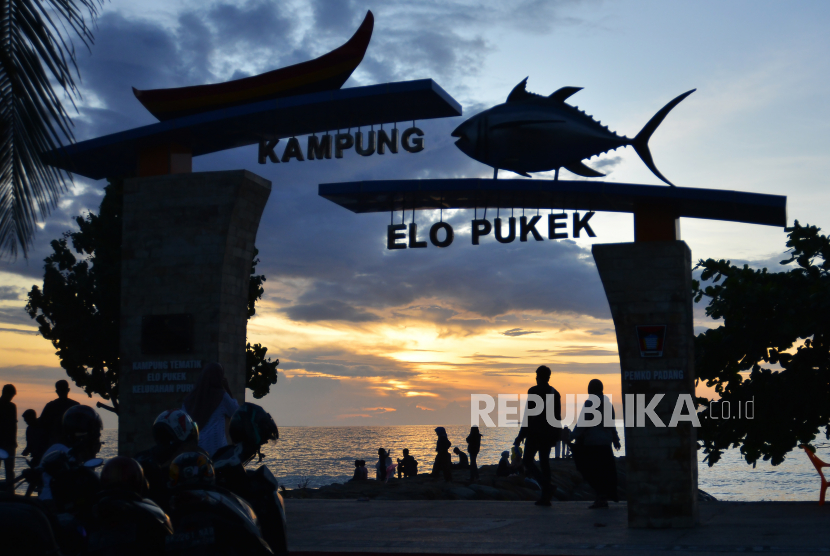 Siluet pengunjung menikmati suasana matahari terbenam di Pantai Padang, Sumatera Barat, Sabtu (31/12/2022). 