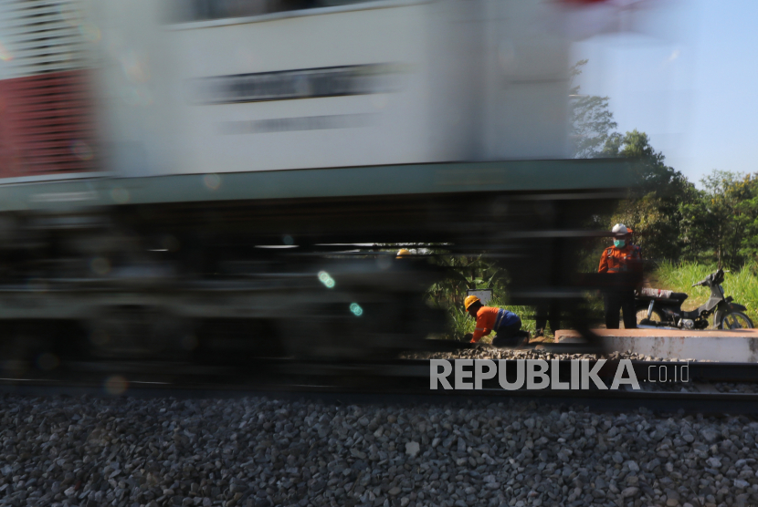 Kereta api melintas saat petugas menutup bakal perlintasan sebidang kereta api di Desa Baye, Kediri, Jawa Timur, Selasa (25/8/2020). PT Kereta Api Indonesia Daop 7 menutup sejumlah bakal perlintasan ilegal guna melindungi warga dan perjalanan kereta api dari kecelakaan. 