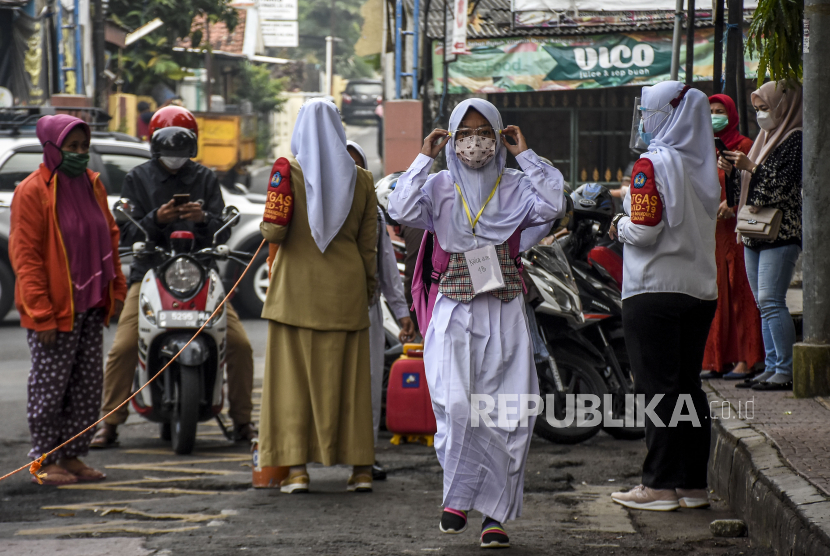 Seorang siswa mengenakan masker dan face shield berjalan memasuki area sekolah saat simulasi pembelajaran tatap muka (PTM), ilustrasi