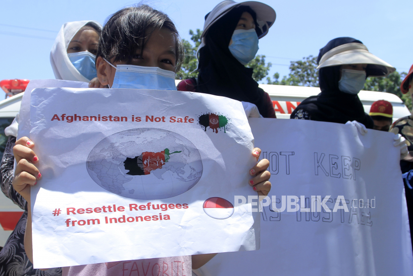 Seorang anak bersama ibunya berujung rasa di depan kantor Kanwil Kemenkumham NTT di Kota Kupang, NTT, Kamis (21/10/2021). Sebanyak 50 pengungsi asal Afghanistan itu menuntut agar Kemenkumham NTT bisa membantu mereka berkoordinasi dengan UNHCR terkait waktu pemindahan mereka ke negara ketiga. 