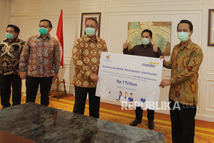 Dirut Bank Mandiri Royke Tumilaar (ketiga kiri) menyerahkan simbolis bantuan perlindungan asuransi bagi tenaga medis yang diterima Ketua Umum Ikatan Dokter Indonesia (IDI) Dr. Daeng M