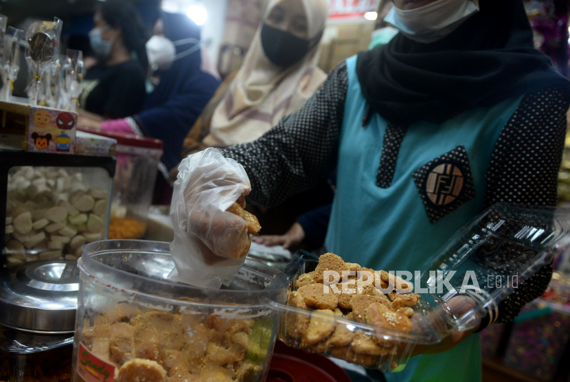 Pedagang melayani membeli makanan ringan dan kue kering di salah satu pusat penjualan kue di pasar Jatinegara, Jakarta, Sabtu (8/5). Dibandingkan dengan tahun 2020 lalu dimana permintaan kue kering merosot tajam, kini ditahun 2021 permintaan kue kering jelang lebaran mengalami kenaikan permintaan hingga 80 persen. Harga kue kering dan aneka makanan ringan tersebut dijual mulai Rp160 ribu hingga Rp180 ribu perkilo tergantung jenisnya.Prayogi/Republika