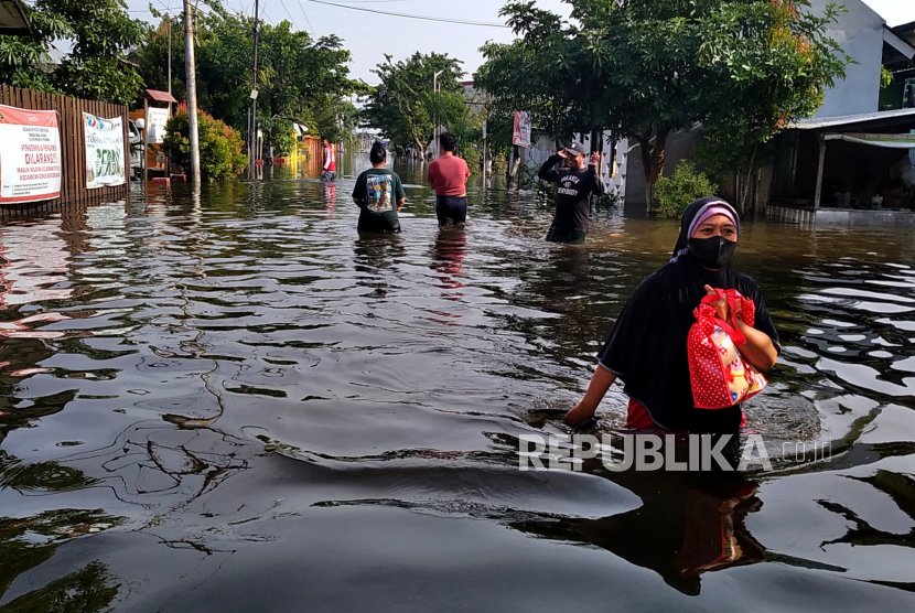 Warga beraktifitas saat banjir di Kelurahan Trimulyo, Genuk, Semarang, Jawa Tengah.
