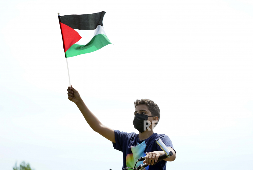 Seorang anak muda memegang bendera saat unjuk rasa mendukung warga Palestina di Dearborn, Mich., Selasa, 18 Mei 2021.