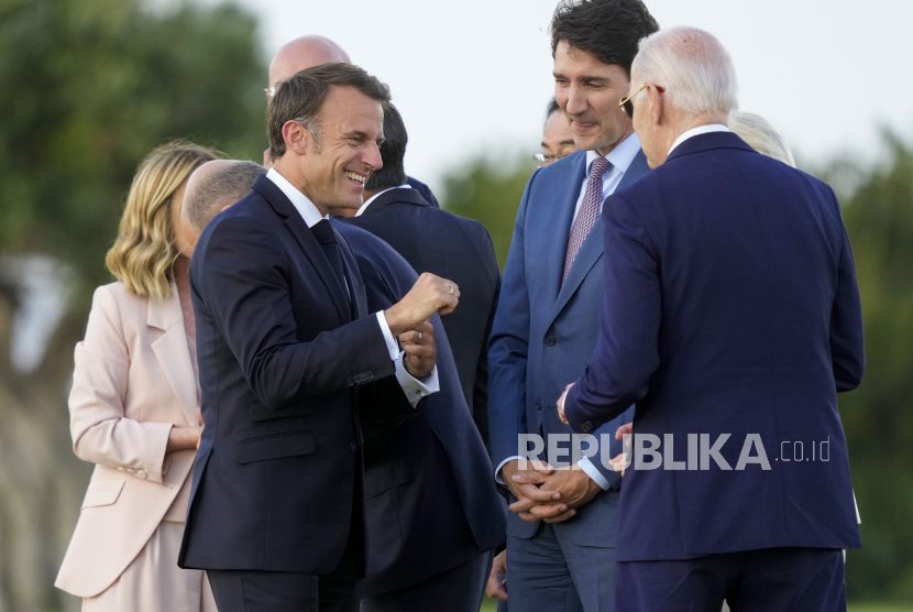 Presiden Prancis Emmanuel Macron (kiri) berbicara dengan Presiden AS Joe Biden di samping Perdana Menteri Kanada Justin Trudeau (tengah) berkumpul untuk menyaksikan demo terjun payung saat KTT para pemimpin dunia G7 di Borgo Egnazia, Italia, Kamis, 13 Juni 2024.