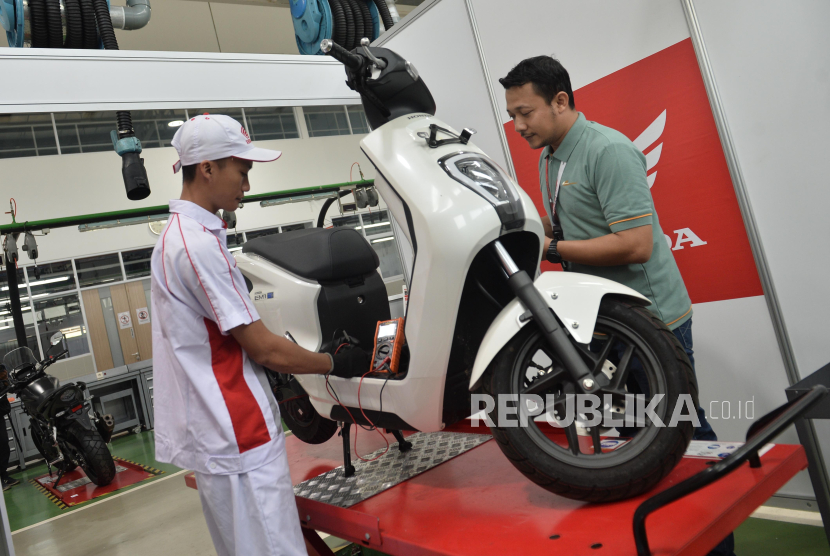 Penguji menilai mekanik melakukan perawatan sepeda motor listrik Honda EM1 e: saat mengikuti kontes Astra Honda Motor Technical Skill Contest (AHM-TSC) 2024 di Cikarang, Kabupaten Bekasi, Jawa Barat, Jumat (23/8/2024). PT Astra Honda Motor (AHM) pada kontes kali ini menggunakan Honda EM1 e: sebagai salah satu materi uji untuk memastikan kesiapan menghadapi era sepeda motor listrik dan para teknisi diuji terkait penguasaan teknologi serta proses perawatannya.