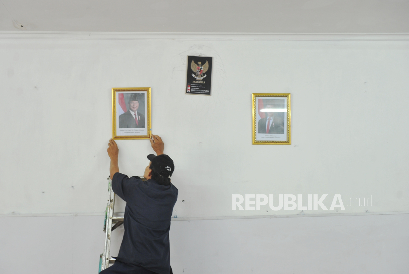 Petugas memasang bingkai foto Presiden Prabowo Subianto dan Wakil Presiden Gibran Rakabuming Raka di SDN Pondok Labu 14 Pagi, Pondok Labu, Jakarta Selatan, Senin (21/10/2024).