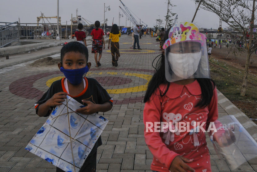Sejumlah anak bermain menggunakan masker dan pelindung wajah di Cilincing, Jakarta Utara, Selasa (11/8/2020). Penelitian menunjukkan bahwa anak-anak tak terlindungi dari Covid-19.  