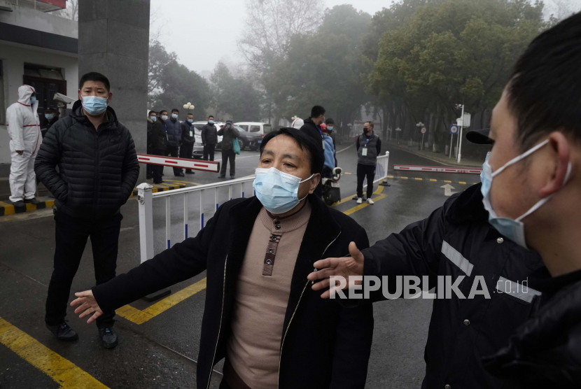 Personel keamanan menahan wartawan di pintu masuk ke Pusat Pengendalian dan Pencegahan Penyakit Hubei di mana tim Organisasi Kesehatan Dunia melakukan kunjungan lapangan di Wuhan di provinsi Hubei China tengah pada Senin (1/2/2021). Tim misi WHO yang menyelidiki asal-usul pandemi virus korona di Wuhan.