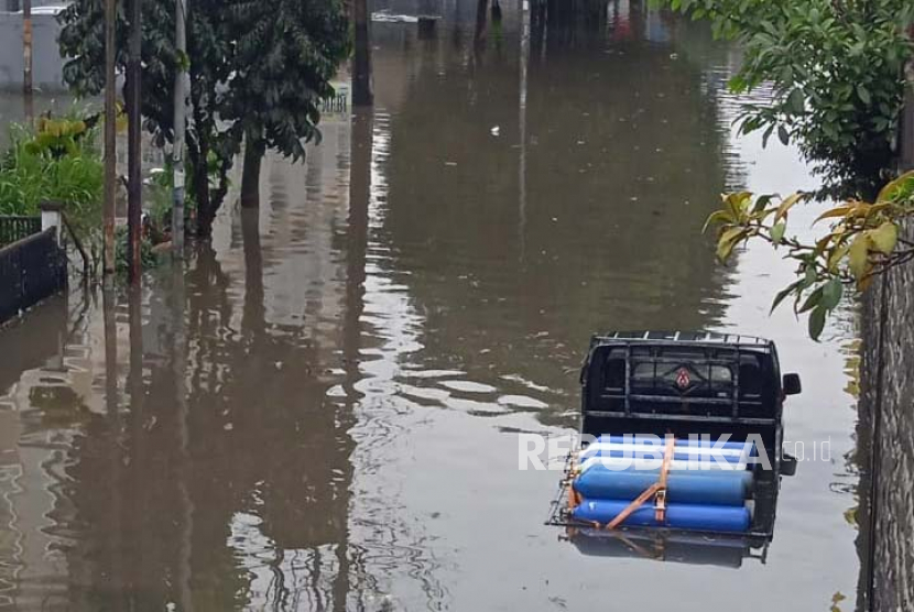 Sebuah kendaraan bak terbuka sempat terjebak di tengah genangan banjir di ruas jalan raya bawah Flyover Cimindi, Kota Cimahi, Jawa Barat, Jumat (24/2/2023). 