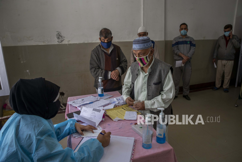 Seorang pria Kashmir mendaftarkan dirinya sebelum menerima vaksin COVISHIELD untuk COVID-19 di sebuah pusat kesehatan primer di Srinagar, Kashmir yang dikendalikan India, Rabu, 28 April 2021. India, negara berpenduduk hampir 1,4 miliar orang, Rabu menjadi negara keempat yang menyeberang. 200.000 kematian.