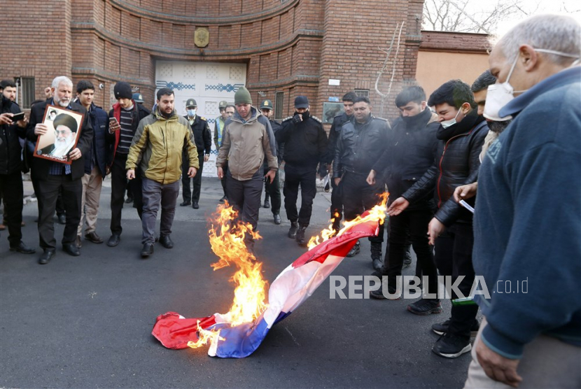  Warga Iran membakar bendera Prancis selama demonstrasi protes anti-Prancis di depan kedutaan Prancis di Teheran, Iran, Ahad (8/1/2023). Iran dengan keras mengutuk penerbitan kartun yang menggambarkan pemimpin tertinggi Iran Aayatollah Ali Khamenei oleh majalah Prancis Charlie Hebdo. 