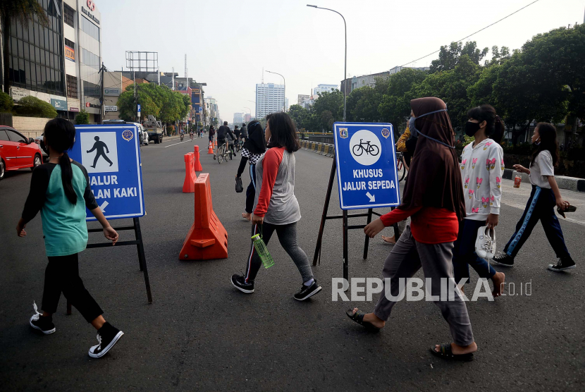 Warga berolahraga saat Hari Bebas Kedaraan Bermotor (HBKB) atau Car Free Day (CFD) di Jalan Gajah Mada, Jakarta, Ahad (28/6). Pemprov DKI Jakarta menggelar HBKB di 32 lokasi baru untuk menggantikan HBKB yang ditiadakan di jalan Sudirman-Thamrin dengan alasan menghindari terjadinya krumunan warga untuk mencegah penyebaran Covid-19.Prayogi/Republika