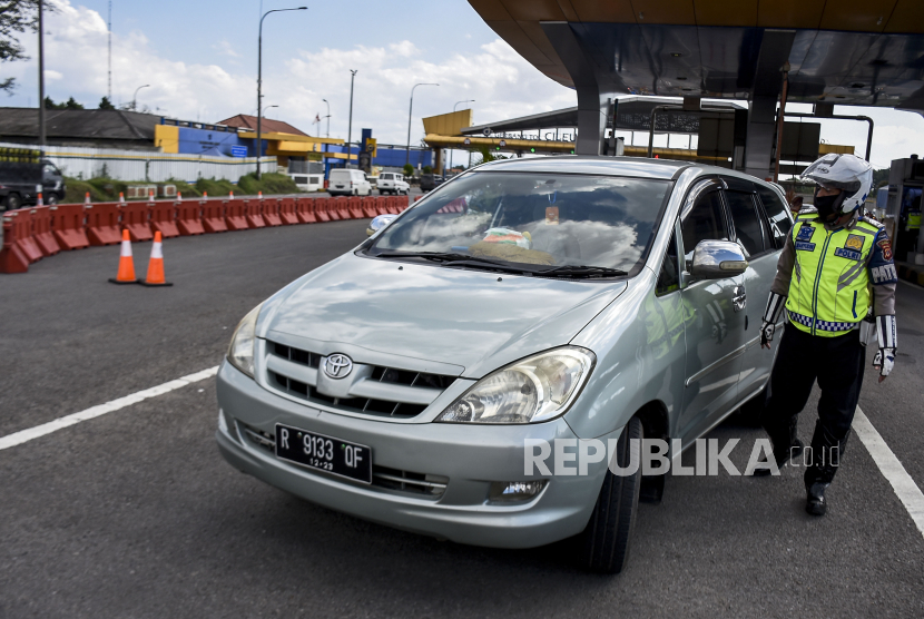 Petugas kepolisian mengarahkan kendaraan untuk memutar balik di Gerbang Keluar Tol Cileunyi, Kabupaten Bandung, Sabtu (23/5). Ilustrasi