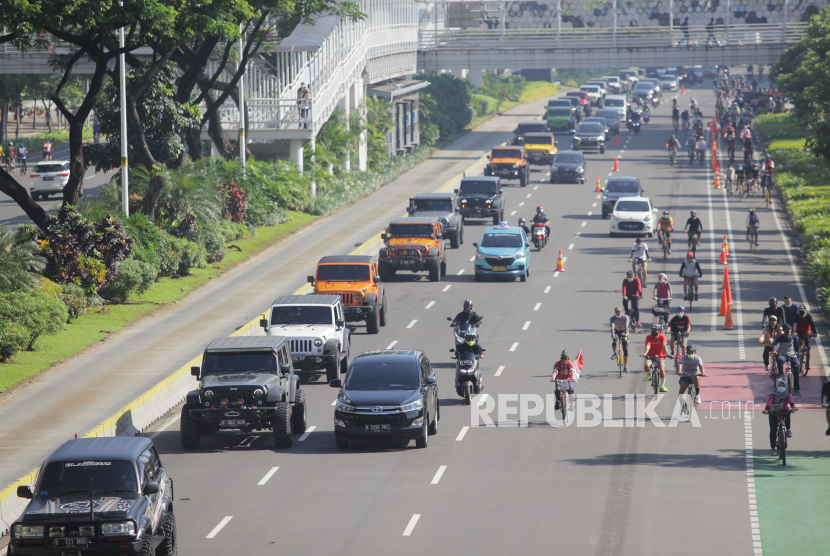 Sejumlah kendaraan  melintasi jalan Sudirman, Jakarta, Ahad (28/3/2021). Pemerintah Provinsi DKI Jakarta memperpanjang masa pemberlakukan pembatasan kegiatan masyarakat (PPKM) mikro hingga 5 April 2021. 