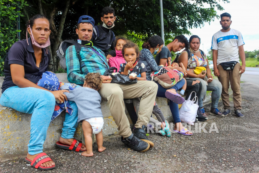 Keluarga migran beristirahat di trotoar yang membawa koper dan tas. Meksiko menyelamatkan 22 warga asing sebagian besar warga Kuba dan Haiti. Ilustrasi.