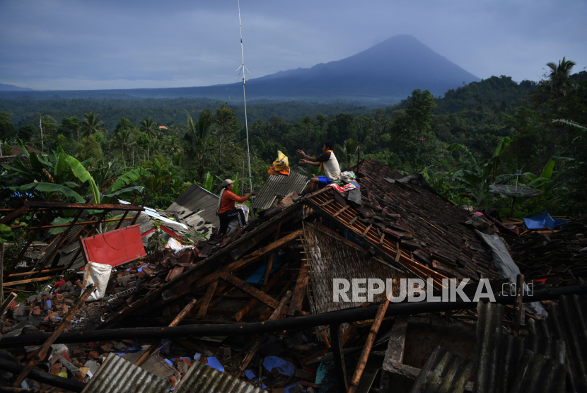 Warga mengumpulkan barang berharga miliknya di antara reruntuhan rumah yang rubuh akibat gempa di Desa Kali Uling, Lumajang, Jawa Timur, Ahad (11/4/2021). . Sekitar ratusan rumah warga di wilayah itu rusak akibat gempa bermagnitudo 6,1 SR yang terjadi di Kabupaten Malang pada Sabtu (10/4). 