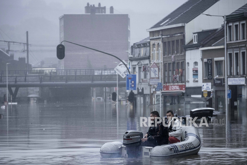 Warga menggunakan rakit karet di tengah banjir setelah Sungai Meuse jebol saat banjir besar di Liege, Belgia, Kamis, 15 Juli 2021. 