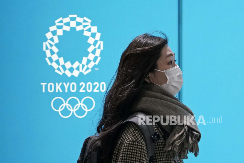  Seorang wanita berjalan melewati papan iklan Olimpiade Tokyo yang ditunda di Tokyo, Jepang, 27 Januari 2021. Komite Olimpiade Internasional akan mengadakan pertemuan Dewan Eksekutif mengenai Olimpiade Tokyo yang dijadwalkan ulang untuk dibuka pada 23 Juli 2021. 