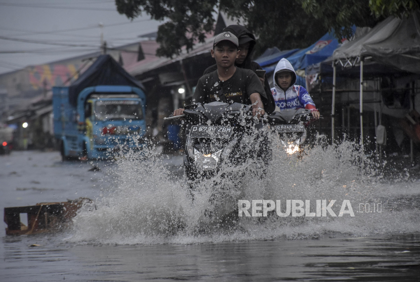 Pengendara melintasi genangan banjir di Pasar Gedebage, Bandung, Jawa Barat, Jumat (1/12/2023). Kawasan tersebut kerap dilanda banjir akibat drainase yang buruk.