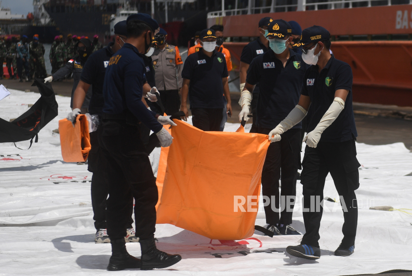 Petugas membawa kantong jenazah berisi bagian tubuh korban pesawat Sriwijaya Air SJ 182 rute Jakarta - Pontianak yang hilang kontak di perairan Pulau Seribu, di Dermaga JICT, Jakarta, Senin (11/1/2021). 
