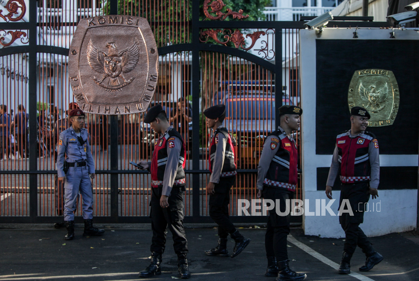 Polisi berjaga di depan gerbang Gedung KPU di Jalan Imam Bonjol, Jakarta, Selasa (19/3/2024). Jelang hasil akhir proses rekapitulasi nasional Pemilu 2024 akses menuju Gedung KPU ditutup untuk peningkatan keamanan.
