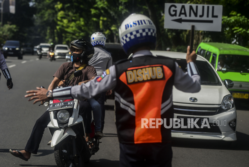 Petugas Dishub memutarbalikkan kendaraan saat pemberlakuan aturan ganjil genap di Jalan Pajajaran, Kota Bogor, Jawa Barat, Ahad (20/6). Pemerintah Kota Bogor kembali memberlakukan aturan ganjil genap untuk kendaraan roda dua dan empat pada setiap akhir pekan untuk mengurangi mobilitas warga sekaligus mengendalikan lonjakan kasus positif Covid-19 di Kota Bogor. Republika/Putra M. Akbar