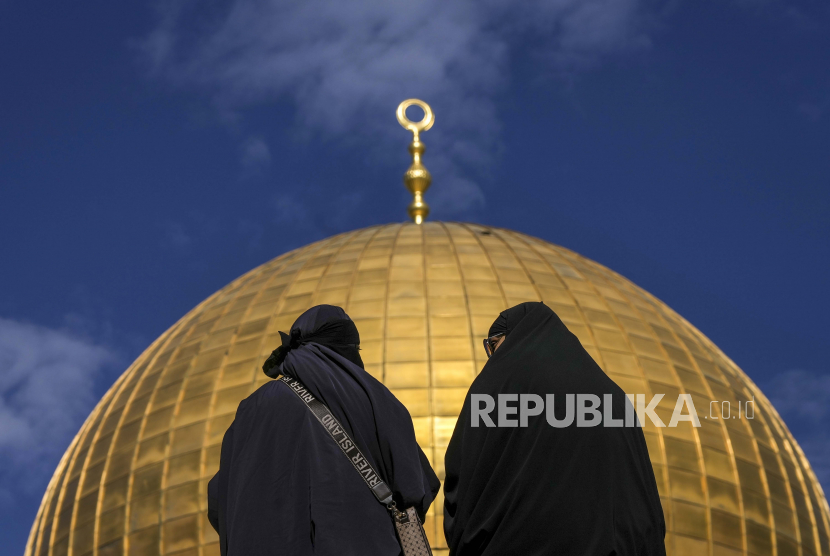 Wanita duduk di dekat Masjid Dome of the Rock di kompleks Masjid Al-Aqsa di Kota Tua Yerusalem, Jumat, 27 Januari 2023.
