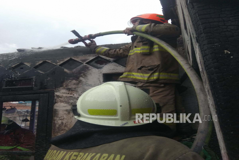 Petugas pemadam kebakaran Kota Bandung tengah memadamkan api pada lantai dua dan tiga rumah warga yang terbakar di Jalan Cijerah, Kecamatan Bandung Kulon, Kota Bandung, Selasa (21/2/2023). 