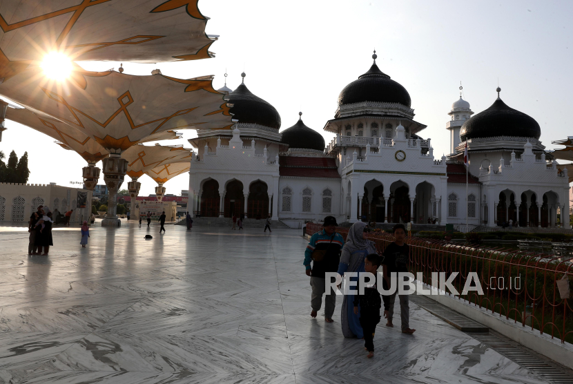 Warga berjalan di halaman Masjid Raya Baiturrahman saat menunggu waktu untuk berbuka puasa (ngabuburit) di Banda Aceh, Aceh, Selasa (12/3/2024). Masjid Raya yang dibangun tahun 1612 pada masa pemerintahan Sultan Iskandar Muda itu menjadi pilihan warga untuk ngabuburit. 
