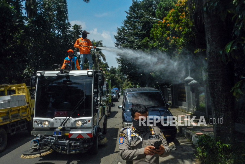 Petugas menggunakan kendaraan penyapu jalan (Road Sweeper) milik Dinas Lingkungan Hidup (DLH) Kabupaten Bogor untuk menyemprotkan cairan disinfektan di Jalan KSR Dadi Kusmayadi, Cibinong, Kabupaten Bogor, Jawa Barat, Selasa (24/3/2020). Penyemprotan disinfektan di jalan tersebut untuk meminimalisir penyebaran COVID-19 di wilayah tersebut