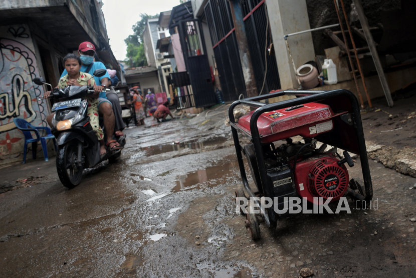 Warga menggunakan genset untuk keperluan listrik di area pemukiman yang terendam banjir di Cipinang Melayu, Jakarta Timur, Senin (22/2). Banjir yang melanda kawasan tersebut pada Jumat (19/2) hingga Minggu (21/2) kini berangsur surut dan warga mulai membersihkan rumah dan barang-barang rumah tangga dari endapan lumpur sisa banjir. Republika/Thoudy Badai