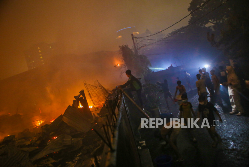 Sejumlah warga menyaksikan kebakaran permukiman di kawasan Tanah Abang, Jakarta Pusat, Ahad (26/2/2023).