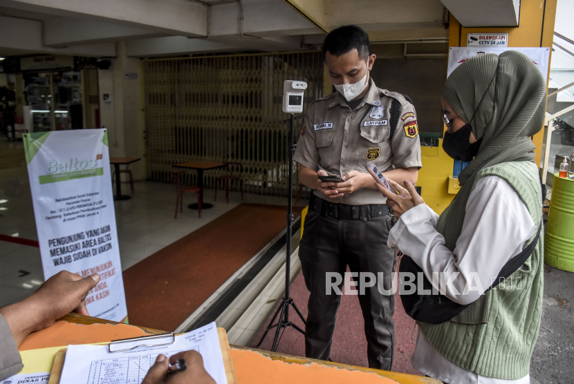 Petugas keamanan memeriksa sertifikat vaksin Covid-19 pengunjung yang hendak memasuki Balubur Town Square (Baltos), Jalan Tamansari, Kota Bandung, Selasa (3/8). Sejumlah pusat perbelanjaan di Kota Bandung mewajibkan pengunjung dan pedagang untuk menunjukkan sertfikat vaksinasi Covid-19 sebagai upaya pencegahan penularan Covid-19 dan mendukung Pemberlakuan Pembatasan Kegiatan Masyarakat (PPKM) Level 4 di Kota Bandung. Foto: Republika/Abdan Syakura