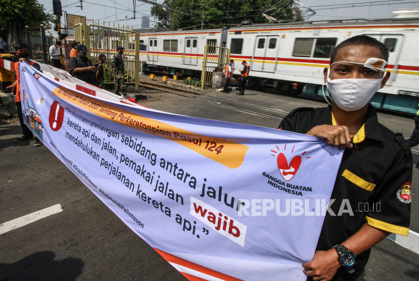Petugas dan relawan melakukan sosialisasi keselamatan di perlintasan sebidang Stasiun Kemayoran, Jakarta, Rabu (14/10/2020). Sosialisasi tersebut bertujuan untuk meningkatkan keselamatan dan menekan angka kecelakaan yang kerap terjadi di perlintasan sebidang. 