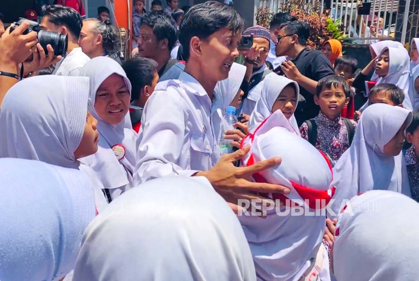 Guru honorer di SDN Cibeureum 1, Mohamad Reza Ernanda, disambut oleh para siswa setelah Wali Kota Bogor Bima Arya, membatalkan pemecatan Reza yang dilakukan secara sepihak oleh kepala sekolah, Rabu (13/9/2023). 